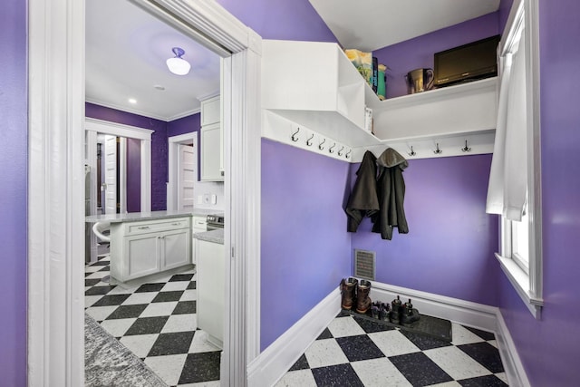 mudroom featuring visible vents, dark floors, and baseboards