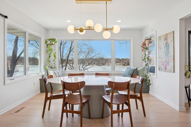 dining space featuring baseboards, visible vents, an inviting chandelier, light wood-style flooring, and recessed lighting