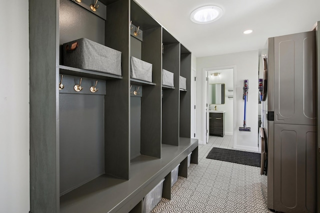 mudroom with recessed lighting, baseboards, and stacked washer / dryer