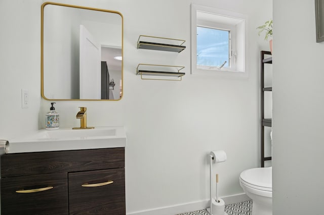 bathroom featuring vanity, toilet, and baseboards