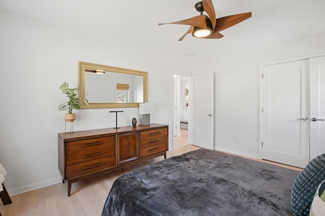 bedroom featuring baseboards, light wood-style floors, and ceiling fan