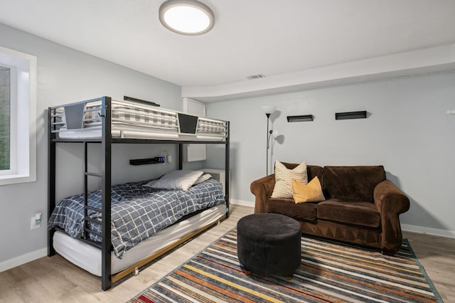 bedroom featuring visible vents, baseboards, and light wood finished floors