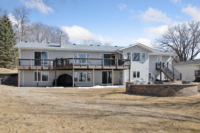 rear view of house with stairway, a deck, and a chimney