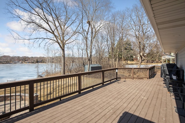 deck with a storage unit, an outdoor structure, and a water view