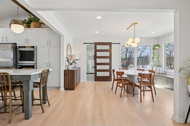 dining room featuring light wood finished floors, recessed lighting, baseboards, and an inviting chandelier