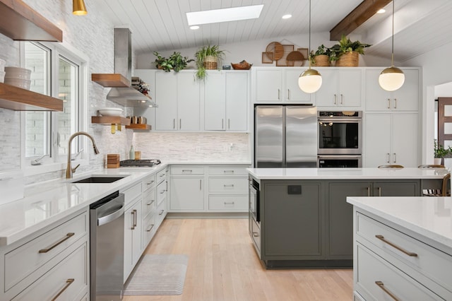 kitchen featuring open shelves, island exhaust hood, tasteful backsplash, vaulted ceiling with skylight, and appliances with stainless steel finishes