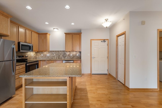 kitchen featuring decorative backsplash, appliances with stainless steel finishes, light stone counters, light wood-style floors, and open shelves