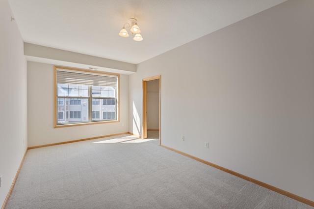 carpeted empty room featuring baseboards