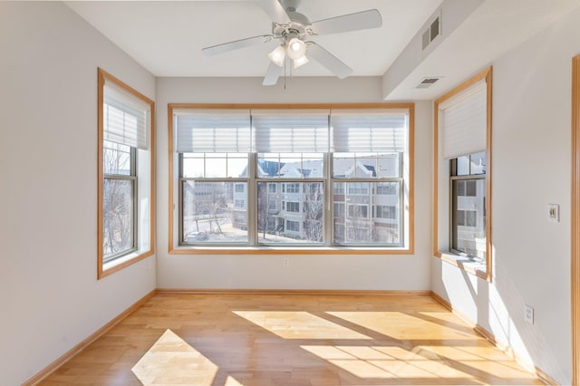 interior space with light wood-style floors, visible vents, and baseboards