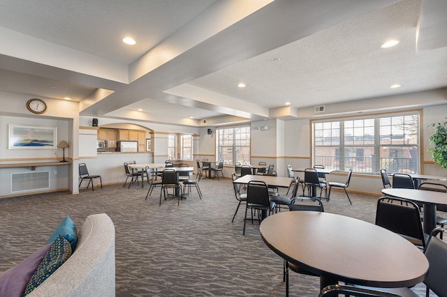 dining room featuring baseboards, visible vents, and dark carpet