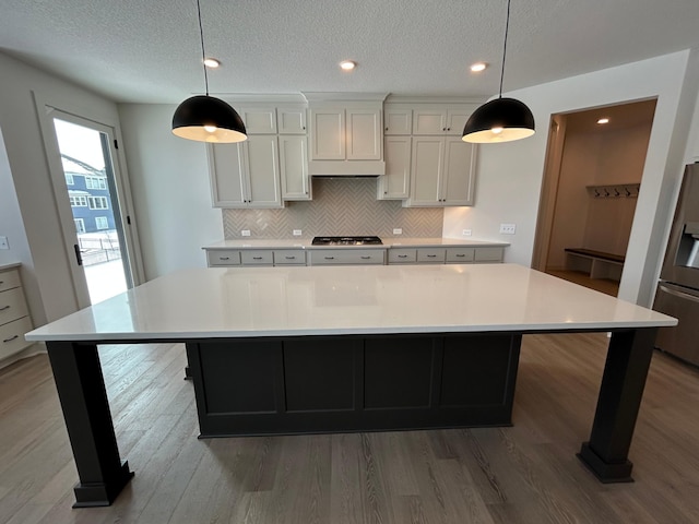 kitchen with a large island, appliances with stainless steel finishes, and light countertops