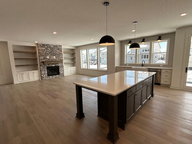 kitchen with a kitchen island, open floor plan, decorative light fixtures, light countertops, and a textured ceiling