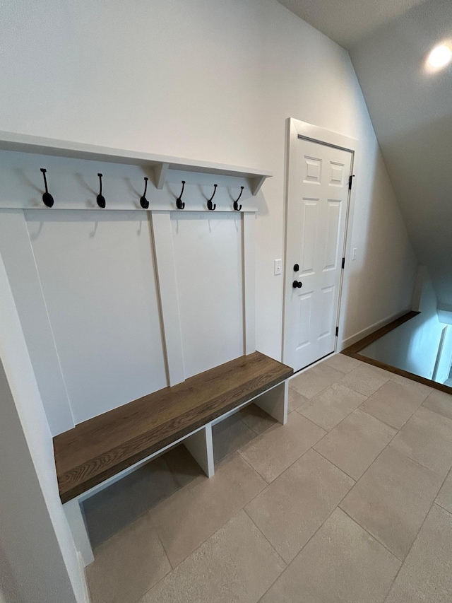 mudroom with vaulted ceiling and light tile patterned floors