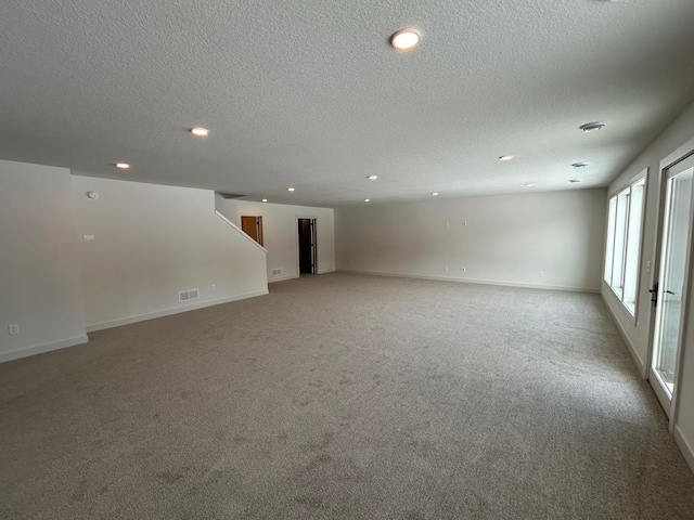 spare room with light carpet, recessed lighting, visible vents, and baseboards