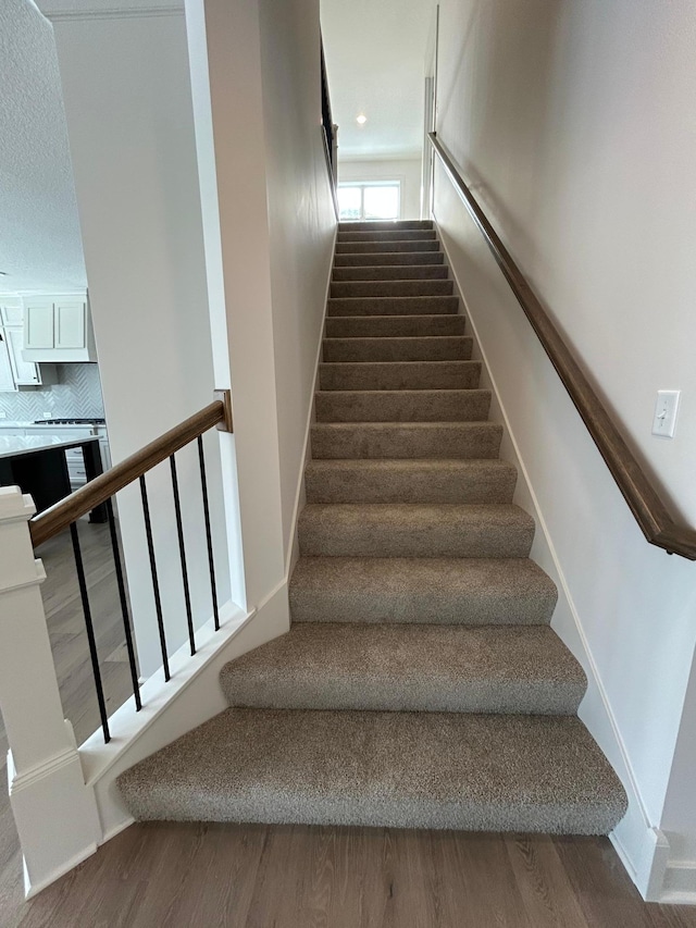 stairs with baseboards and wood finished floors