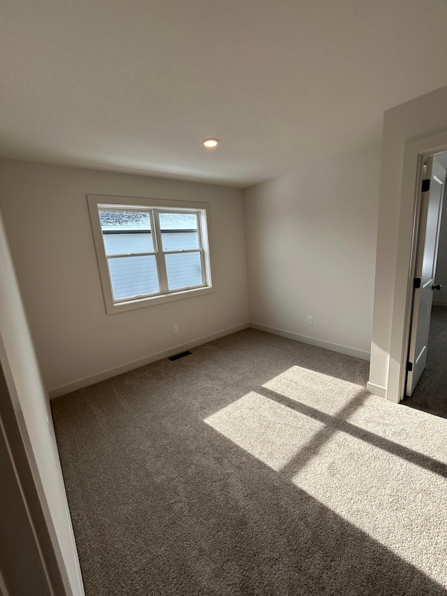 unfurnished room featuring recessed lighting, dark carpet, visible vents, and baseboards