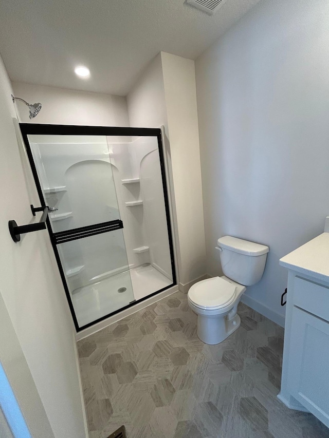 full bathroom featuring toilet, visible vents, vanity, baseboards, and a shower stall