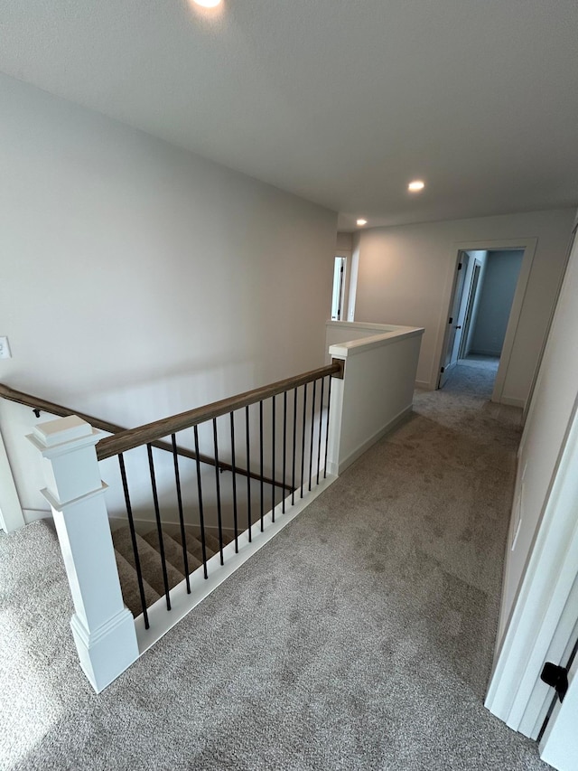 hallway with recessed lighting, carpet, and an upstairs landing