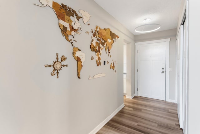 corridor with light wood finished floors and baseboards