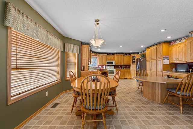 dining space with built in desk and a textured ceiling