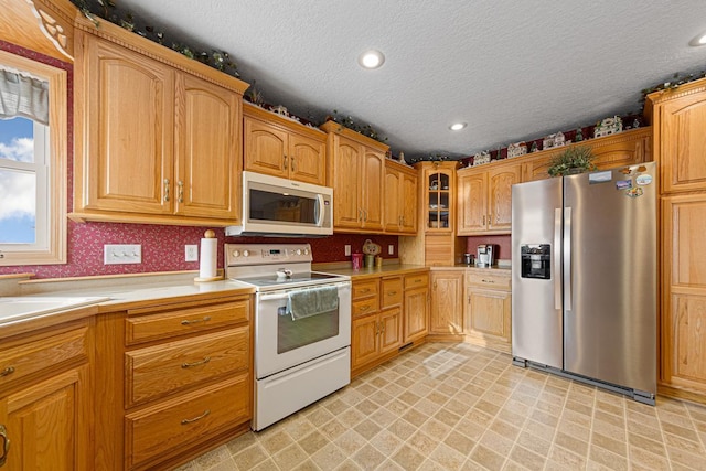 kitchen featuring appliances with stainless steel finishes, sink, and a textured ceiling