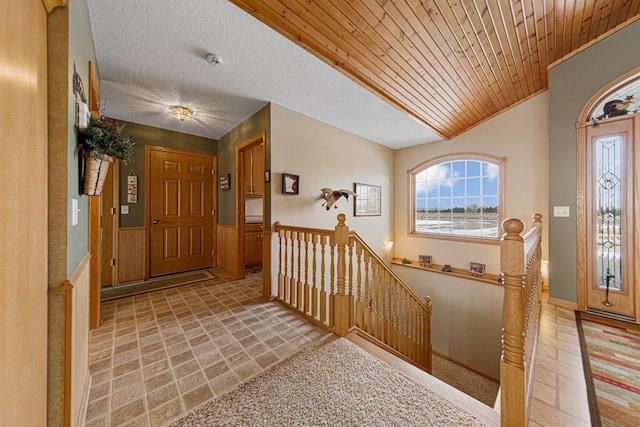 foyer entrance featuring wood ceiling and a textured ceiling