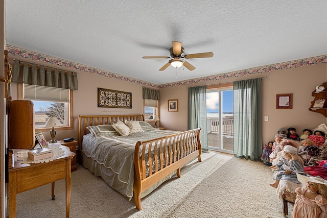 carpeted bedroom featuring ceiling fan, access to outside, and a textured ceiling