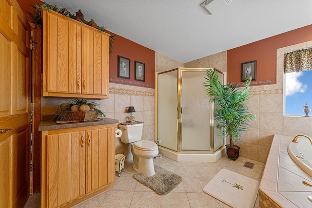 bathroom with independent shower and bath, tile walls, and a textured ceiling