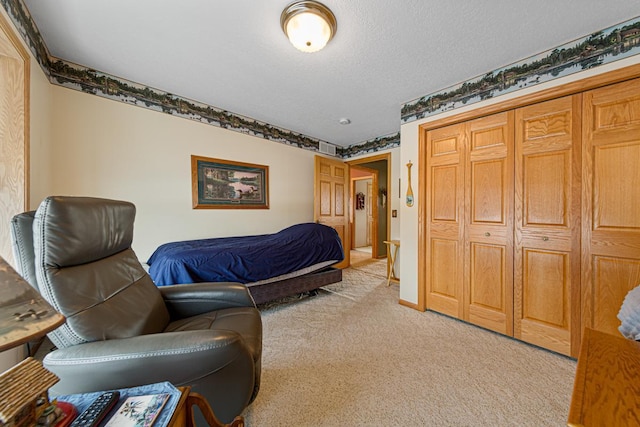 bedroom with light colored carpet, a textured ceiling, and a closet