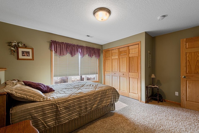 carpeted bedroom featuring a textured ceiling and a closet