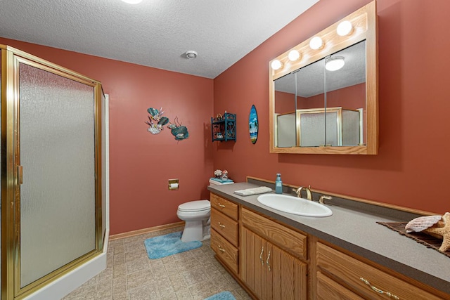 bathroom featuring vanity, a shower with door, toilet, and a textured ceiling