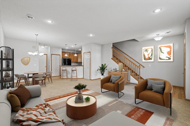 living room featuring a notable chandelier, stairway, a textured ceiling, and recessed lighting