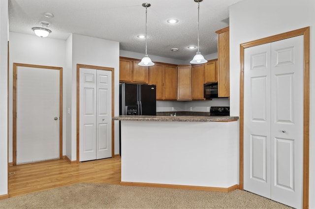 kitchen with light colored carpet, hanging light fixtures, a peninsula, a textured ceiling, and black appliances