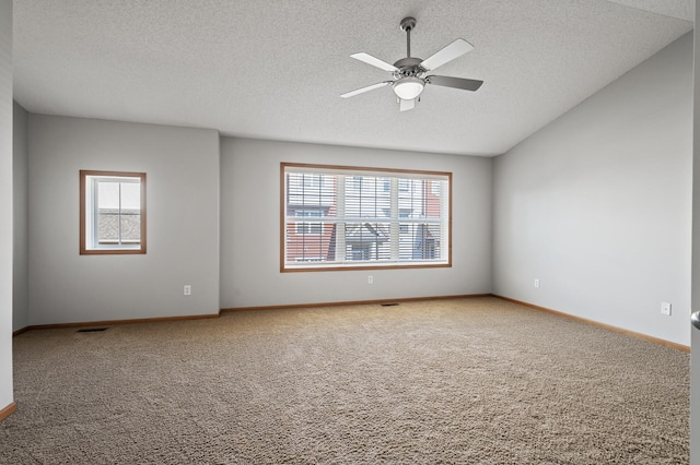 carpeted empty room featuring ceiling fan, a textured ceiling, and baseboards