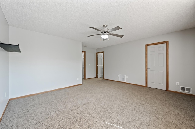 empty room with visible vents, carpet flooring, ceiling fan, a textured ceiling, and baseboards