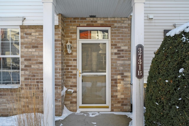 entrance to property featuring brick siding