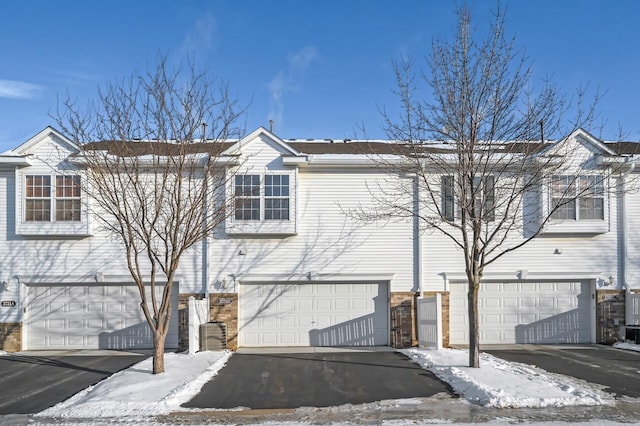 townhome / multi-family property featuring a garage and brick siding