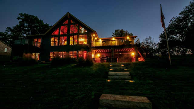 rear view of house featuring a yard, a deck, and stairs