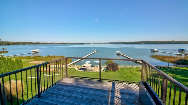 wooden terrace featuring a water view and a yard