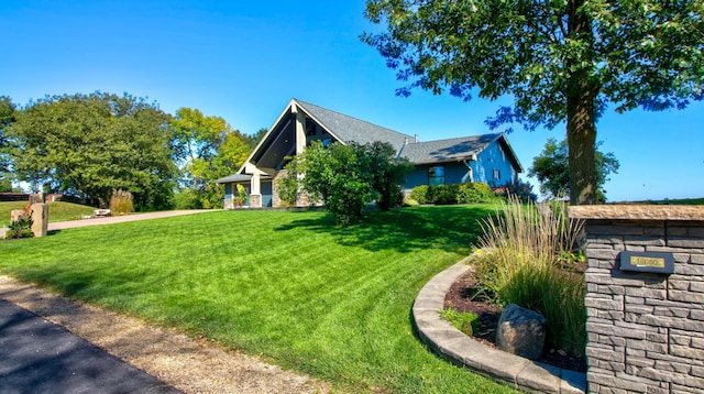 view of front facade with stone siding and a front yard