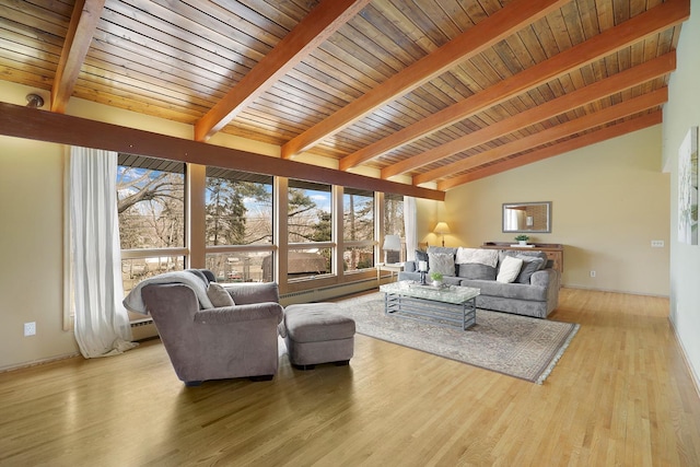 living area with lofted ceiling with beams, a baseboard radiator, plenty of natural light, and wood finished floors