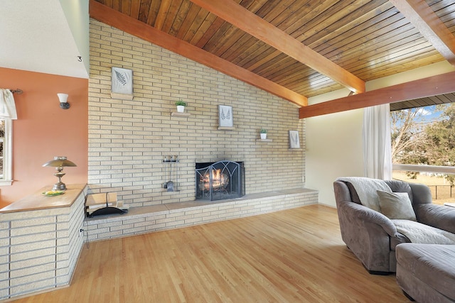 living room featuring lofted ceiling with beams, wood ceiling, wood finished floors, and a fireplace