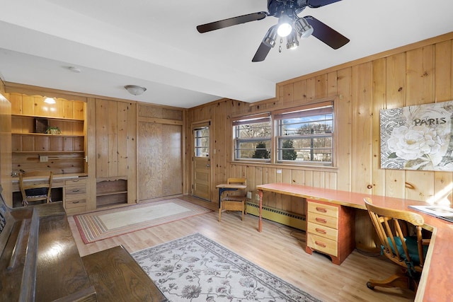 home office with a baseboard heating unit, wood walls, beam ceiling, light wood-style flooring, and built in study area