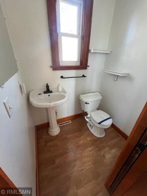 bathroom with wood-type flooring and toilet