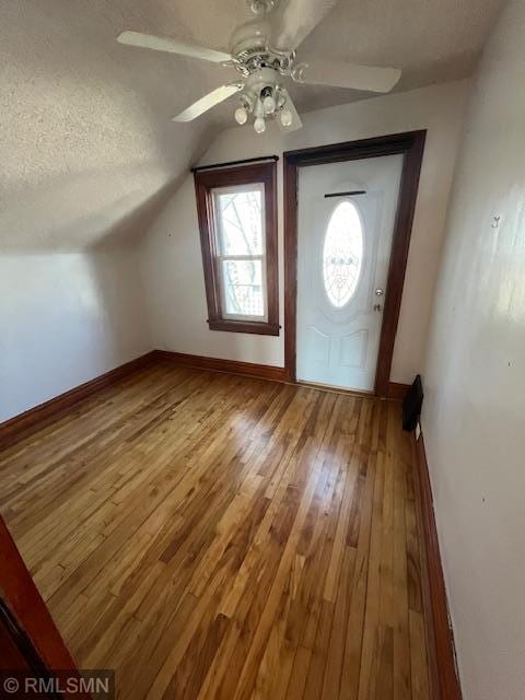 bonus room featuring ceiling fan, hardwood / wood-style flooring, vaulted ceiling, and a textured ceiling