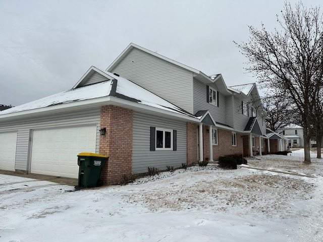 view of snow covered exterior featuring a garage