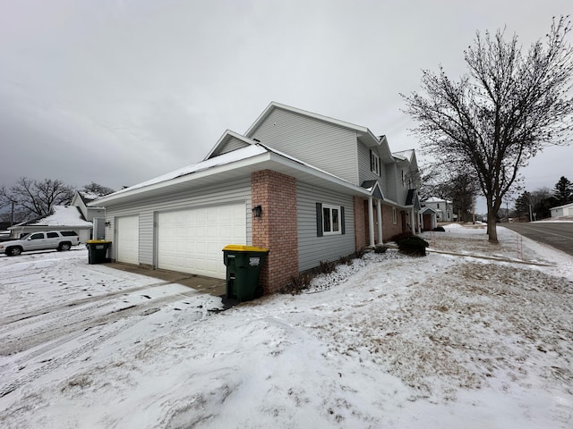 view of snow covered exterior featuring a garage