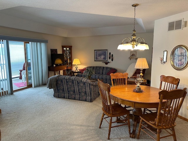 dining area featuring carpet and a notable chandelier