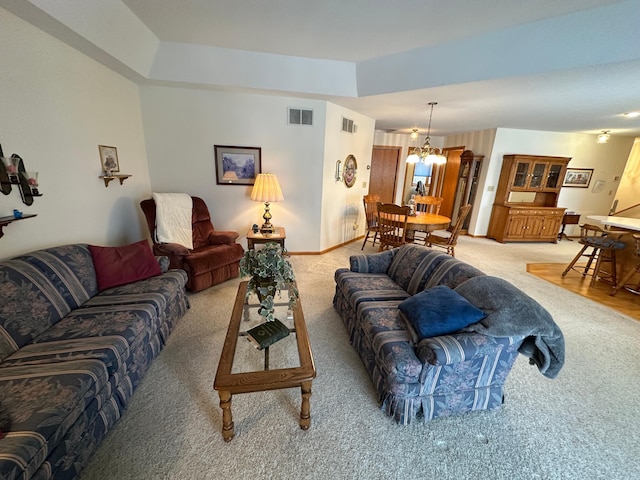 carpeted living room with a chandelier