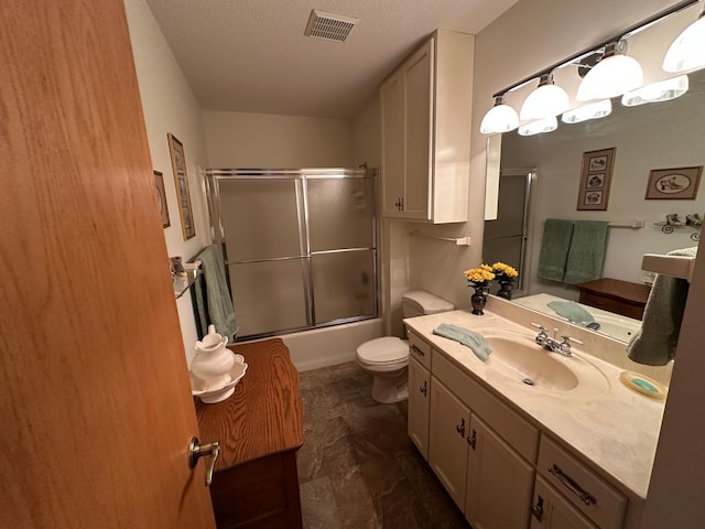 full bathroom with vanity, a textured ceiling, shower / bath combination with glass door, and toilet